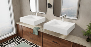 Two square white wall-mounted sinks over a walnut vanity in a bathroom with a patterned floor