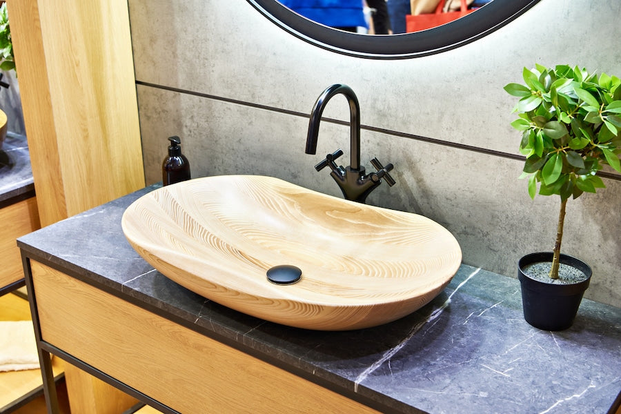Oval vessel basin on a stone vanity top, used to illustrate common bathroom sink sizes
