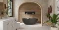 Badeloft BW-10-L freestanding bathtub in matte black in a wood-slat arched alcove with a built-in wall niche