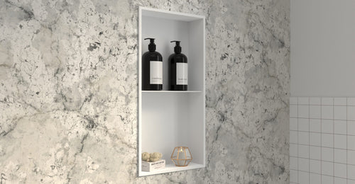Badeloft NS-02 shower niche in matte white set into a marble wall with bottles on the shelves